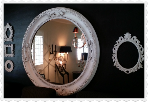 Inexpensive "antique" frames painted white on a black wall. 