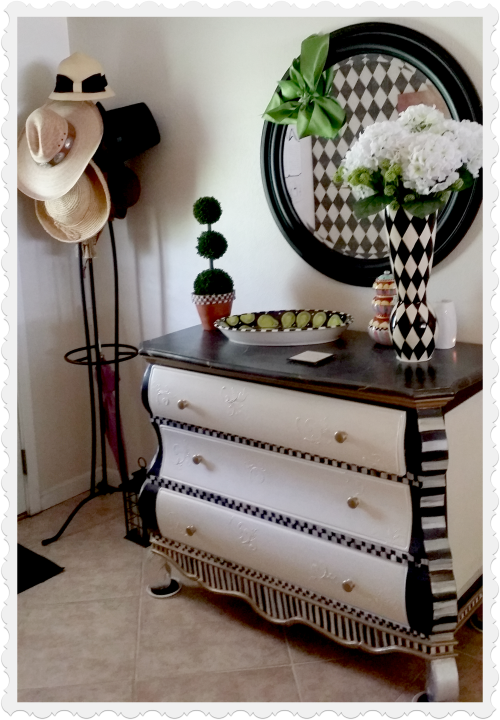Black and white painted dresser adds storage to the front entry.